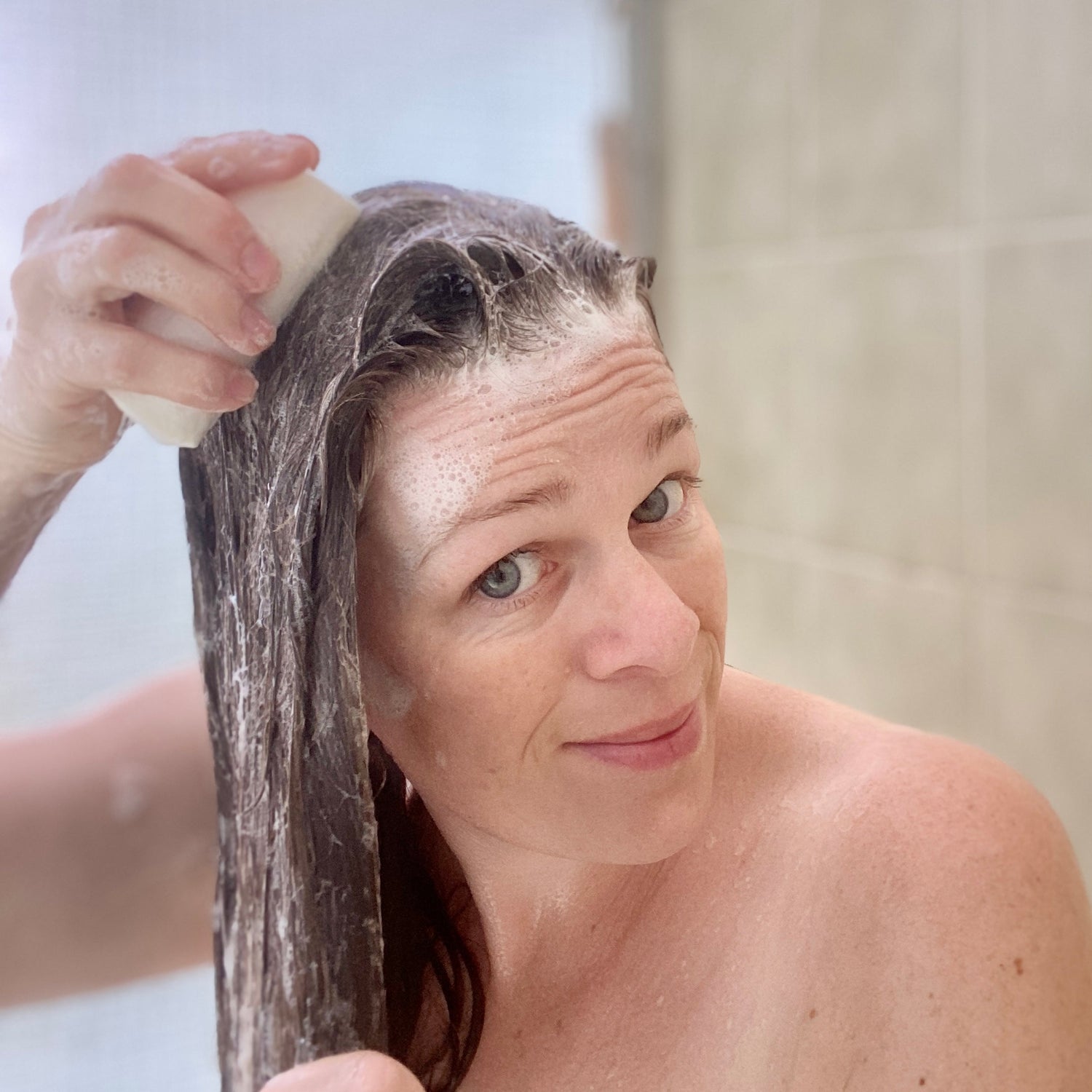 Girl washing hair with a plastic free shampoo bar