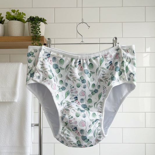 Floral-patterned underwear hanging on a hook against a white wall.