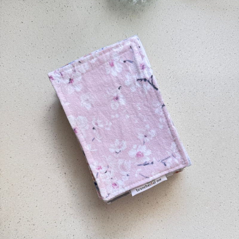 Pink fabric pouch with floral pattern on a light surface