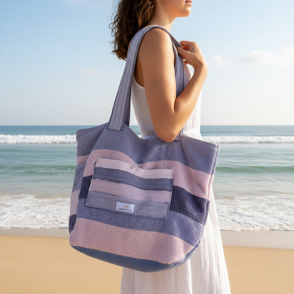 Striped beach bag on a sandy beach with ocean view